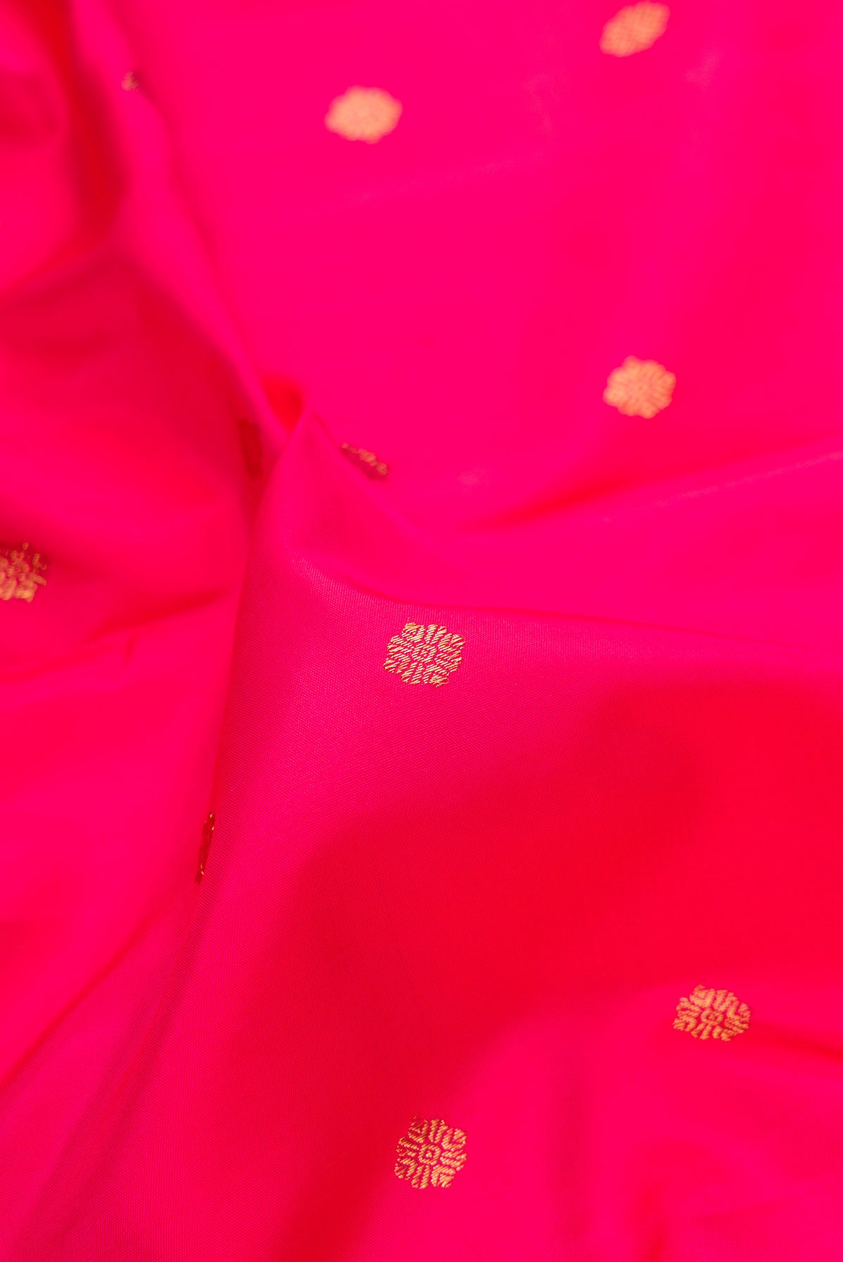 Close up of Pure Silk Pure Zari Dark Pink Kanjivaram Saree with Zari Butta on the body and Fancy Border.  displaying folds