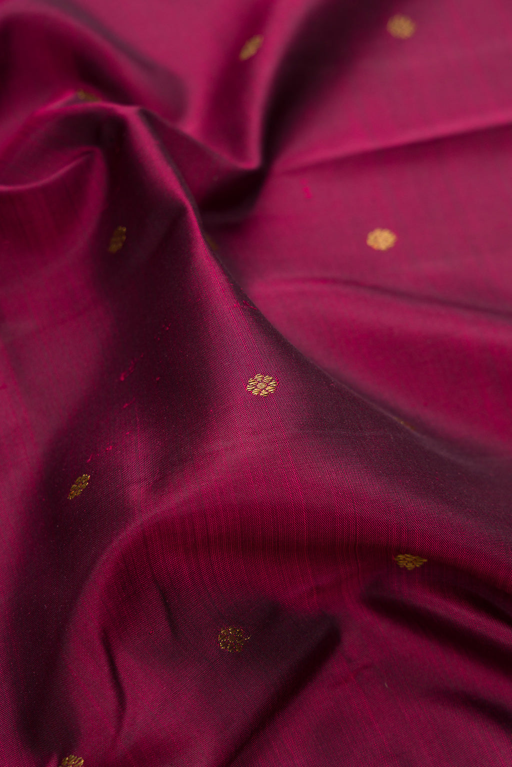 Close up of Pure Silk Pure Zari Maroon Kanjivaram Saree with Zari Butta on the body and Zari Border.  displaying folds