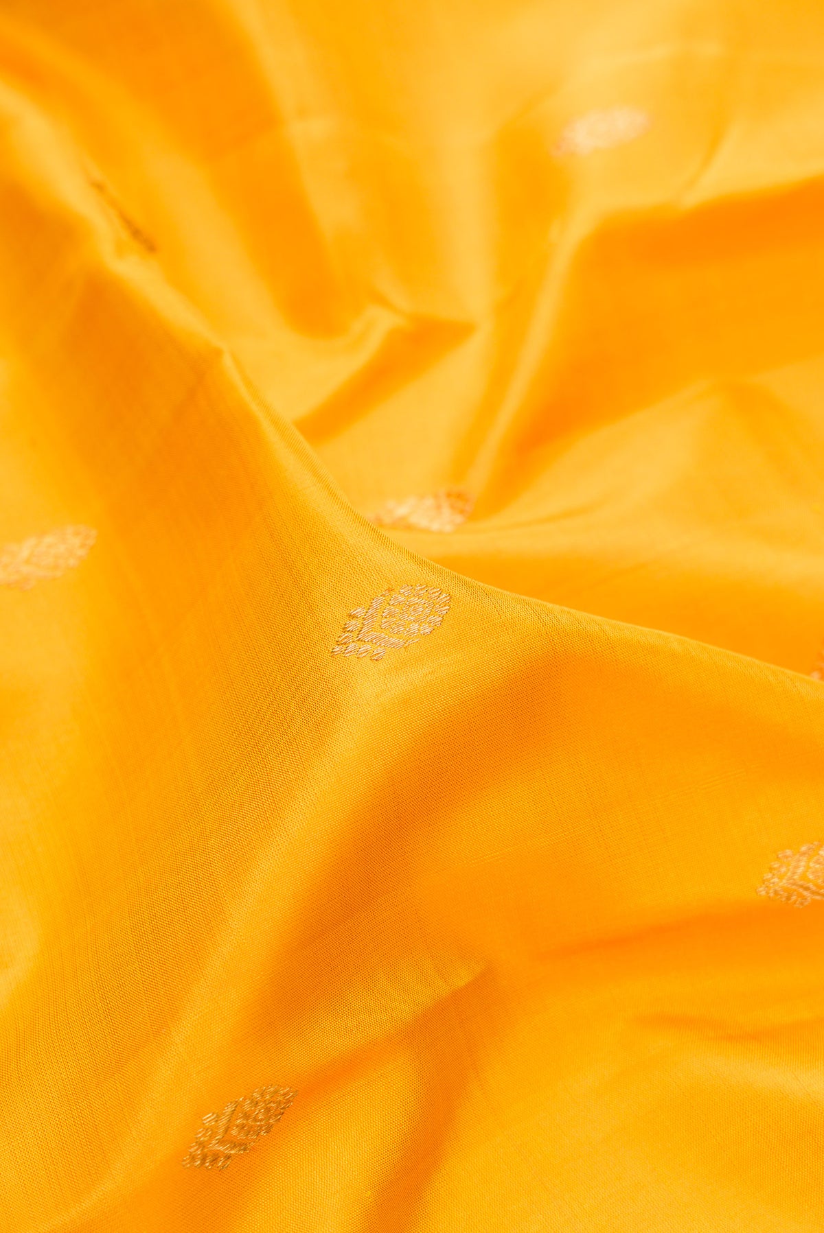 Close up of Pure Silk Pure Zari Yellow Kanjivaram Saree with Zari Butta on the body and Zari Border.  displaying folds