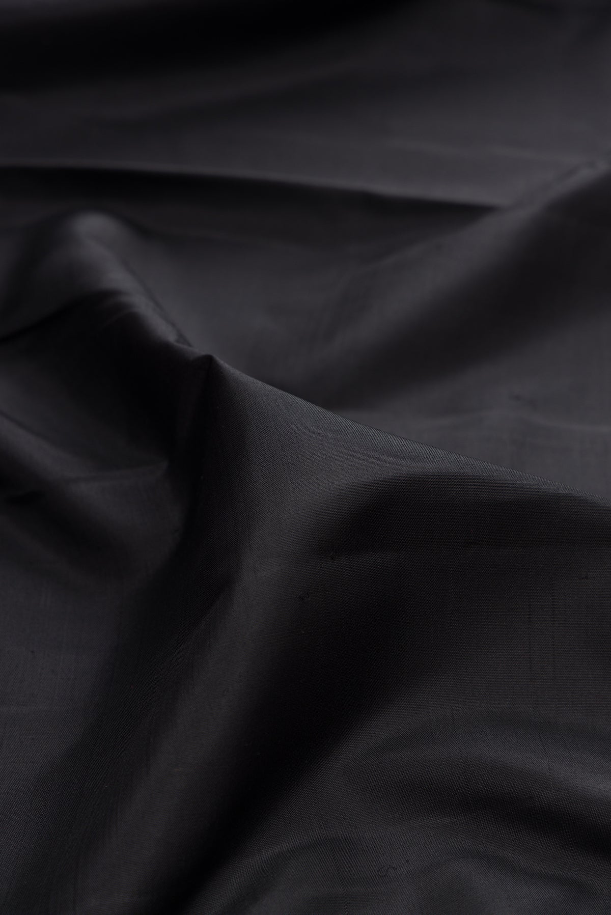 Close up of Pure Silk Pure Zari Black Kanchipuram Saree with Plain Body and Checks Border.  displaying folds