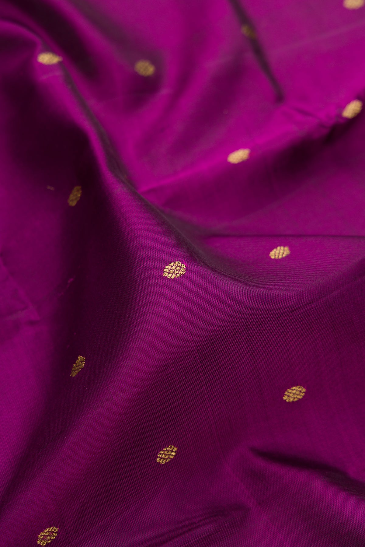 Close up of Pure Silk Pure Zari Purple Dual Tone Kanjivaram Saree with Zari Butta on the body and Zari Border.  displaying folds
