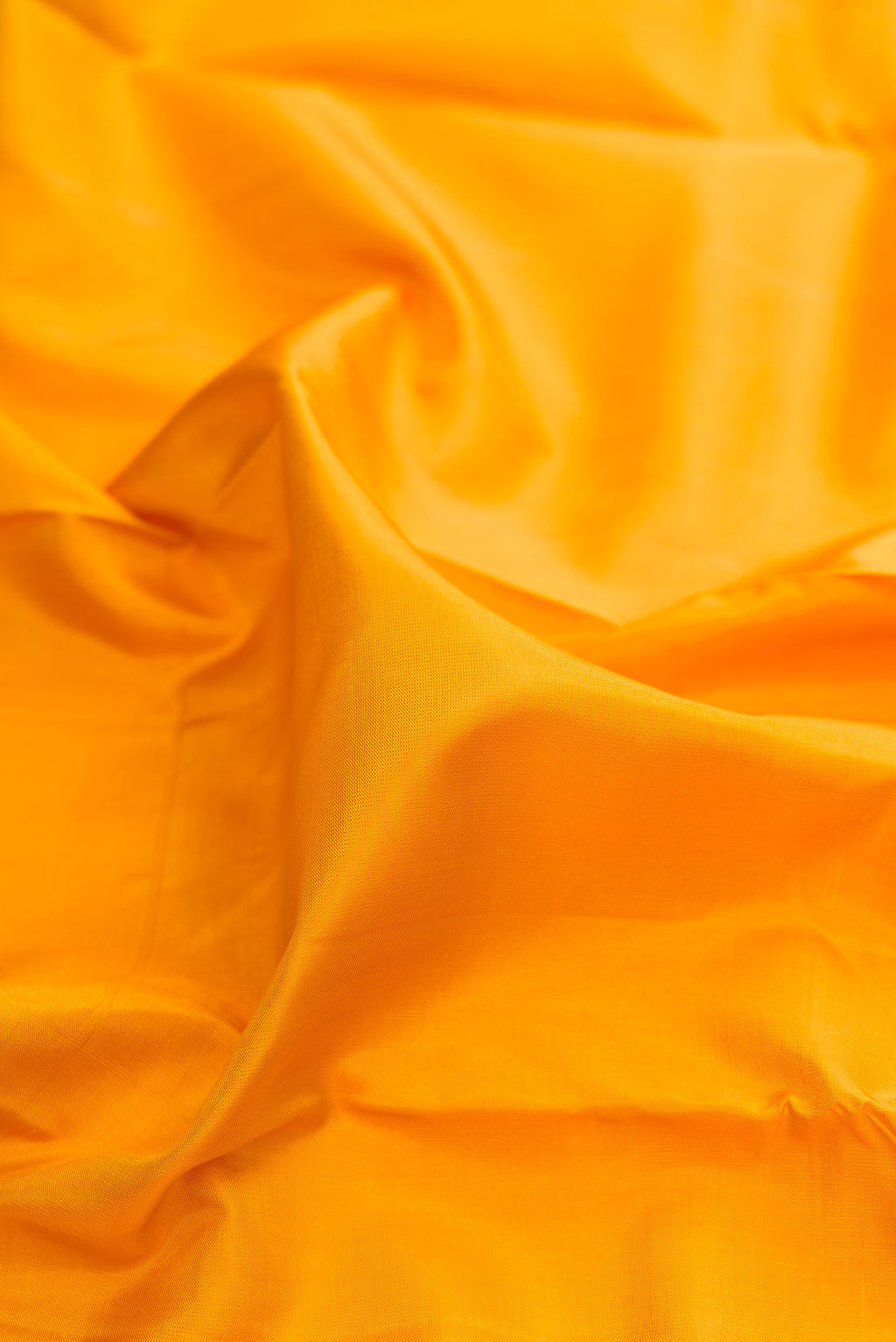 Close up of Pure Silk Mustard Kanjivaram Saree with Plain Body and Temple Border.  displaying folds