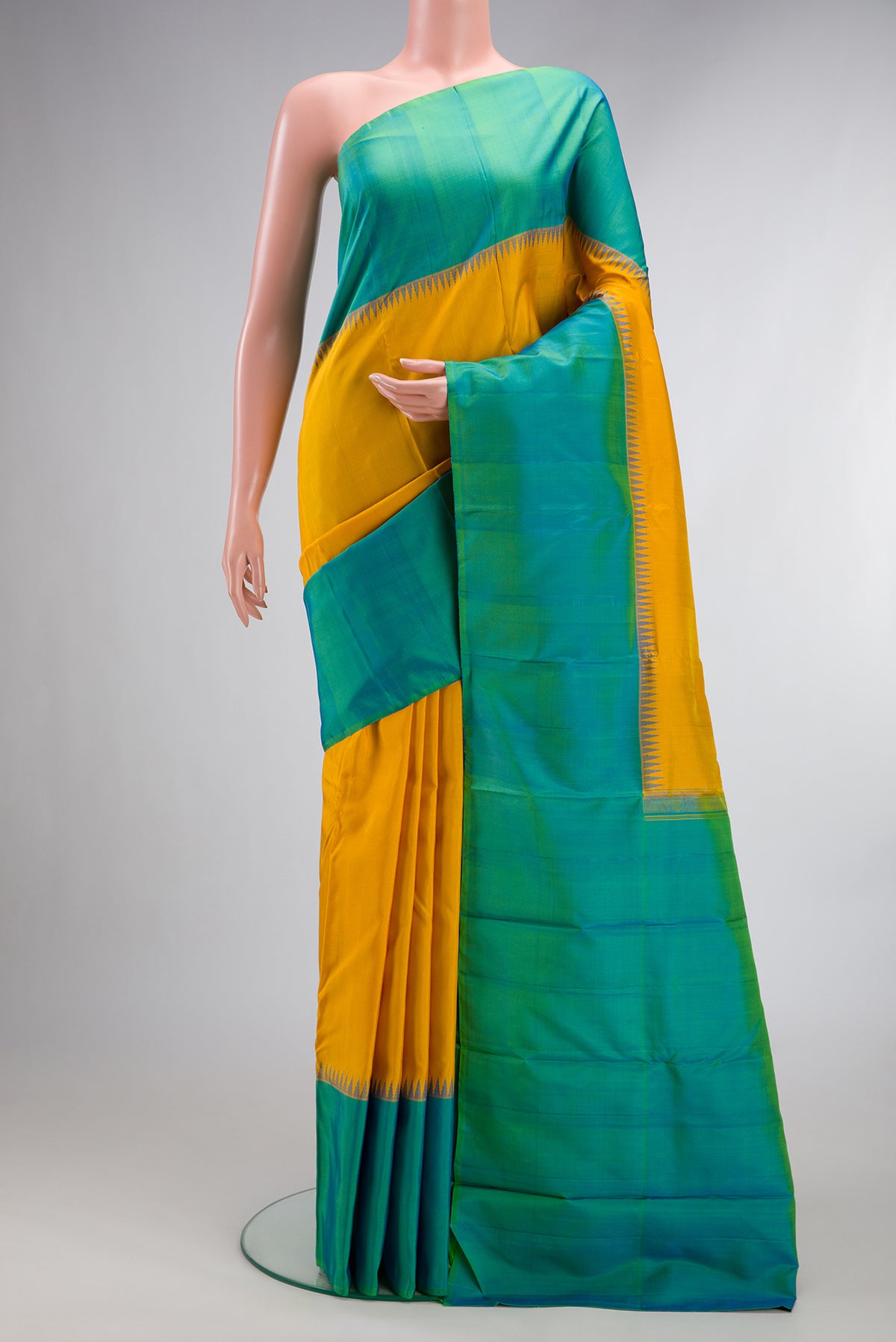 Pure Silk Mustard Kanjivaram Saree with Plain Body and Temple Border.  displayed on a mannequin