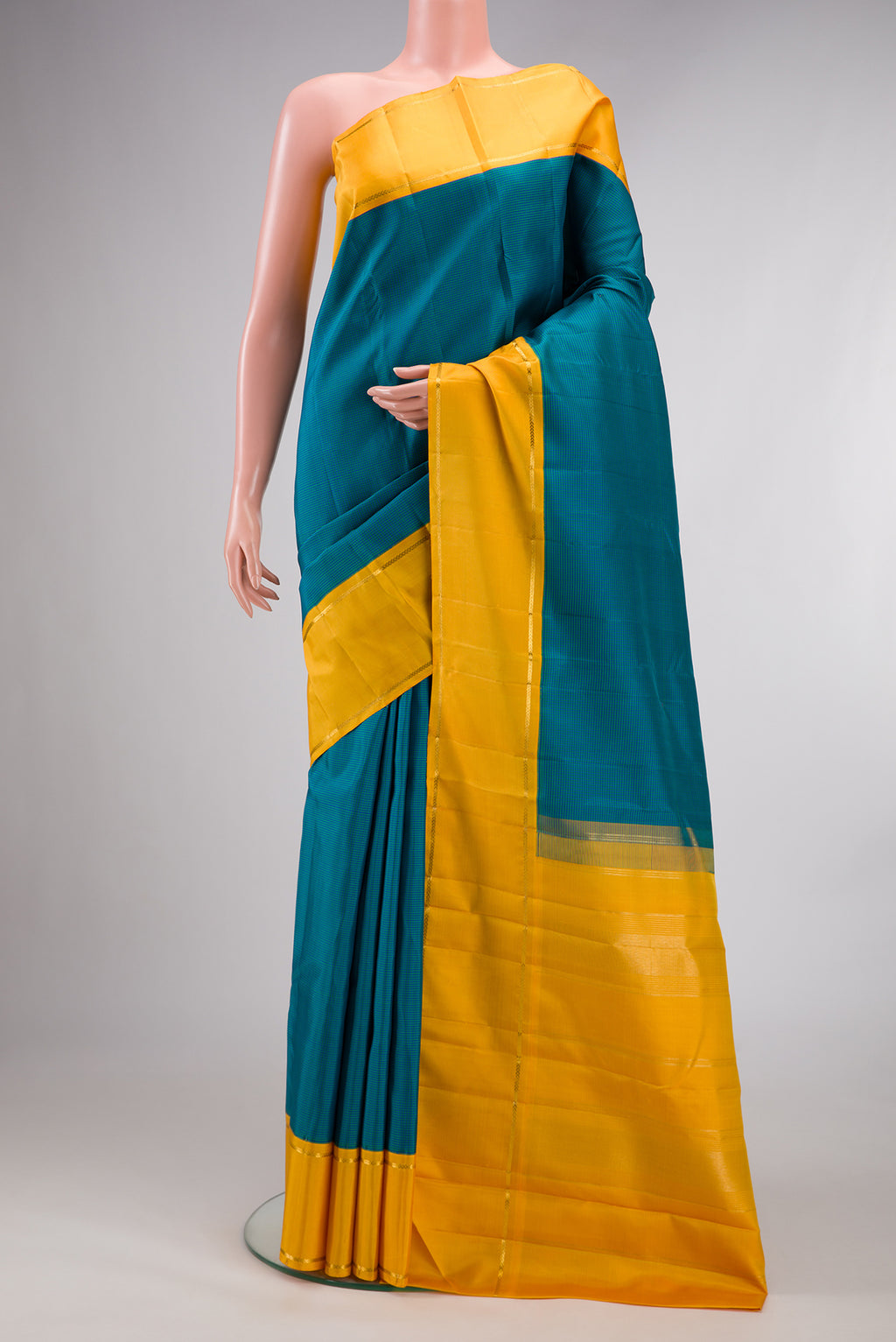 Pure Silk Peacock Blue Dual Tone Kanjivaram Saree with Checked design on the body and Zari Border.  displayed on a mannequin