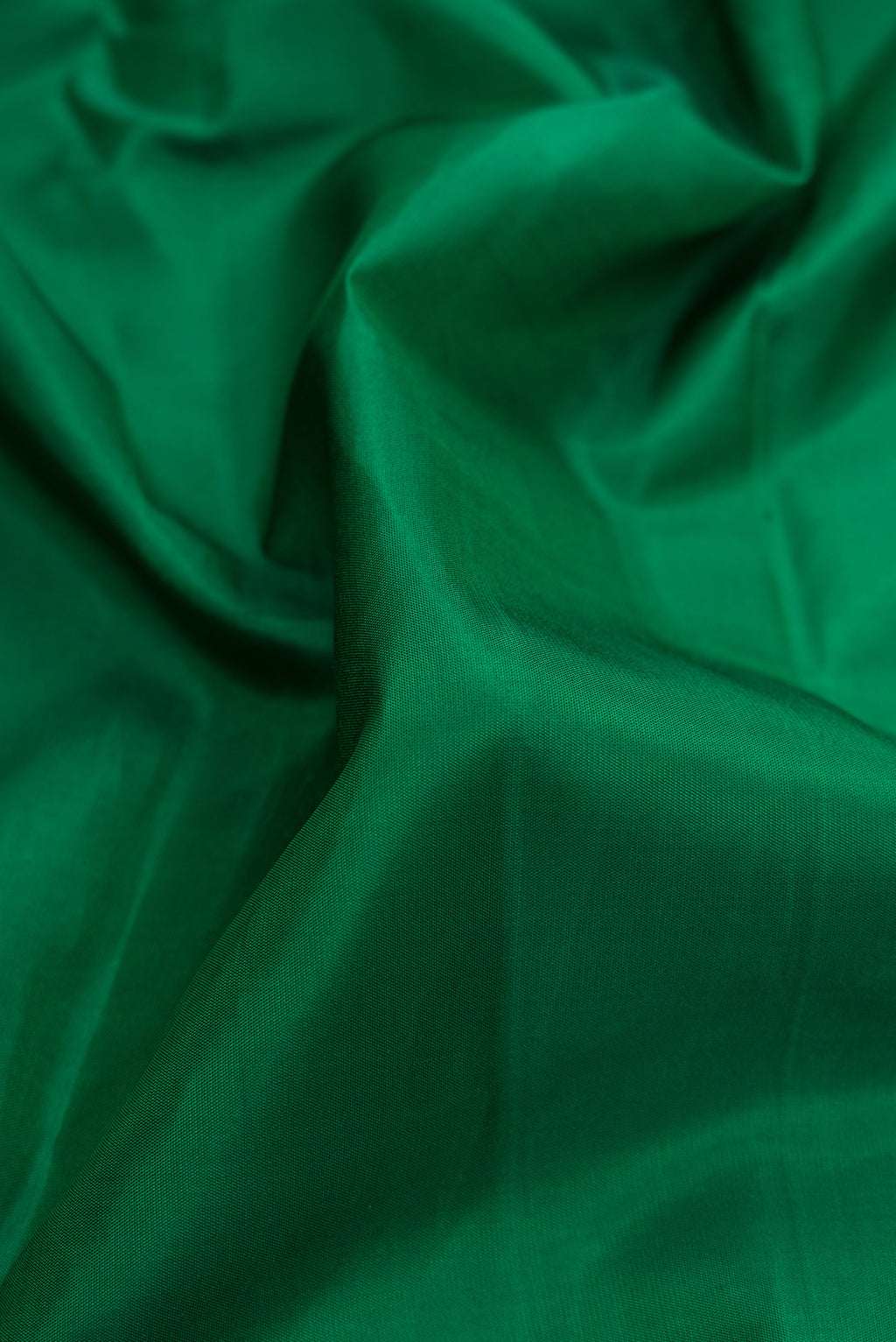 Close up of Pure Silk Green Kanjivaram Saree with Plain Body and Plain Border.  displaying folds