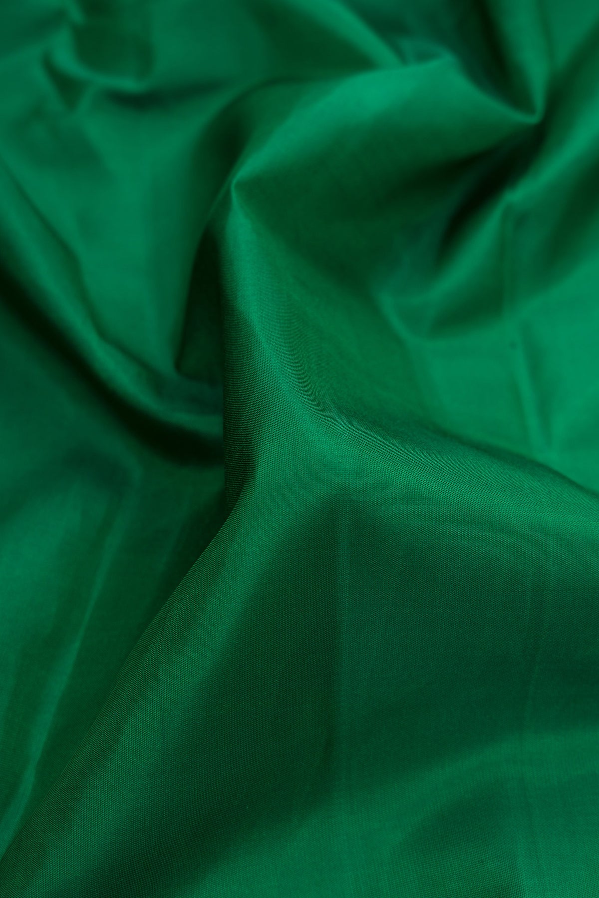 Close up of Pure Silk Green Kanjivaram Saree with Plain Body and Plain Border.  displaying folds