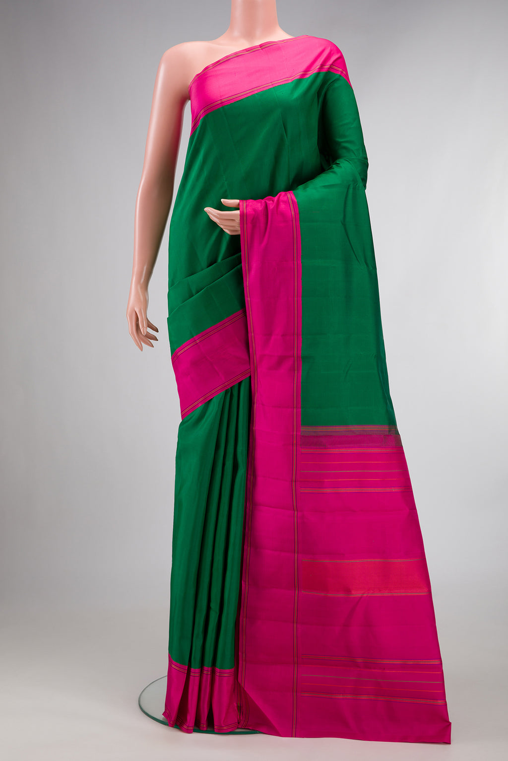 Pure Silk Green Kanjivaram Saree with Plain Body and Plain Border.  displayed on a mannequin