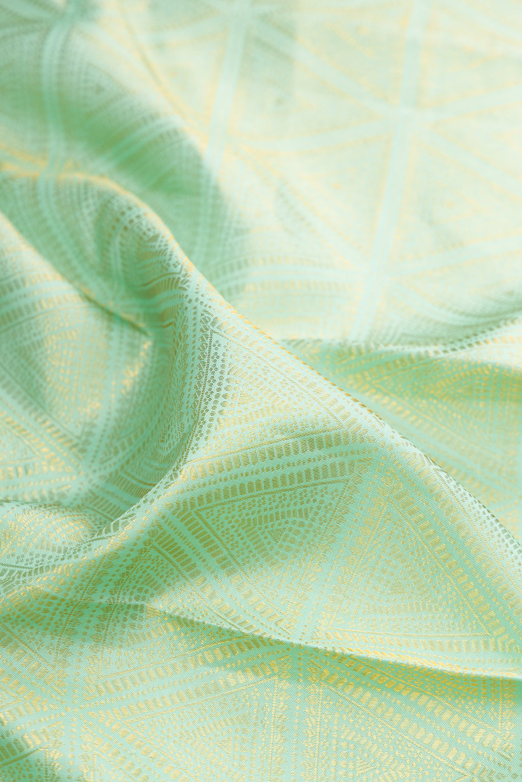 Close up of Pure Silk Mint Green Kanjivaram Saree with Zari Brocade on the body and Zari Border.  displaying folds