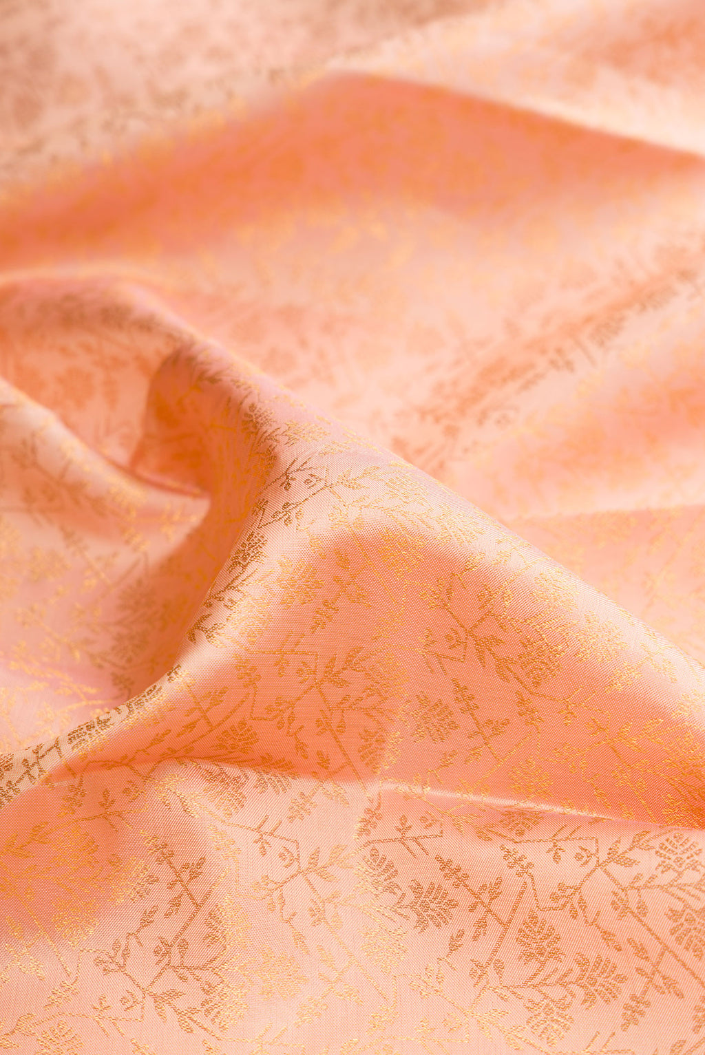 Close up of Pure Silk Golden Peach Dual Tone Kanchipuram Saree with Zari Brocade on the body and Zari Border.  displaying folds