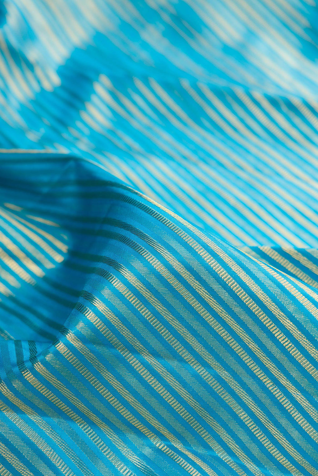 Close up of Pure Silk Sky Blue Kanchipuram Saree with Zari Brocade on the body and Fancy Border.  displaying folds