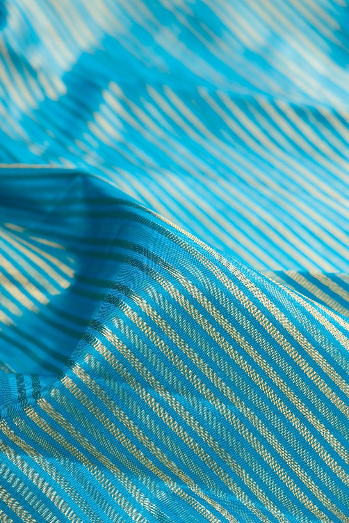 Close up of Pure Silk Sky Blue Kanchipuram Saree with Zari Brocade on the body and Fancy Border.  displaying folds