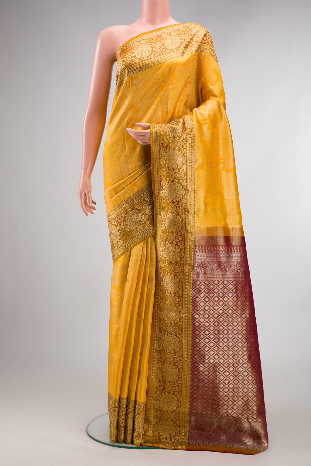 Yellow Kanchipuram Tissue Saree with Zari Brocade on the body and Fancy Border.  displayed on a mannequin