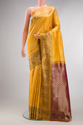 Yellow Kanchipuram Tissue Saree with Zari Brocade on the body and Fancy Border.  displayed on a mannequin