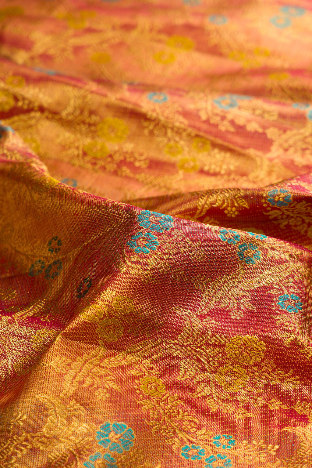 Close up of Pure Silk Maroon Dual Tone Kanjivaram Tissue Saree with Zari Brocade on the body and Zari Border.  displaying folds