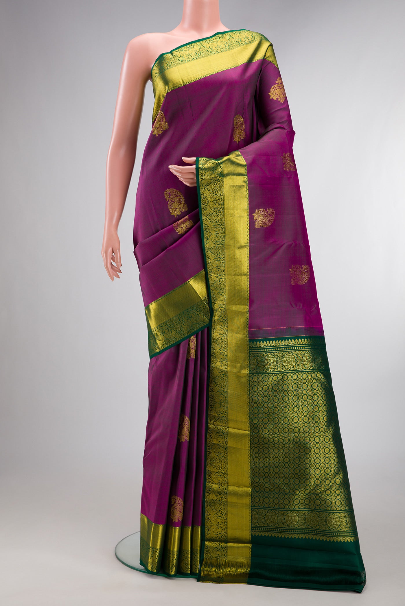 Pure Silk Purple Kanjivaram Saree with Zari Butta on the body and Zari Border.  displayed on a mannequin
