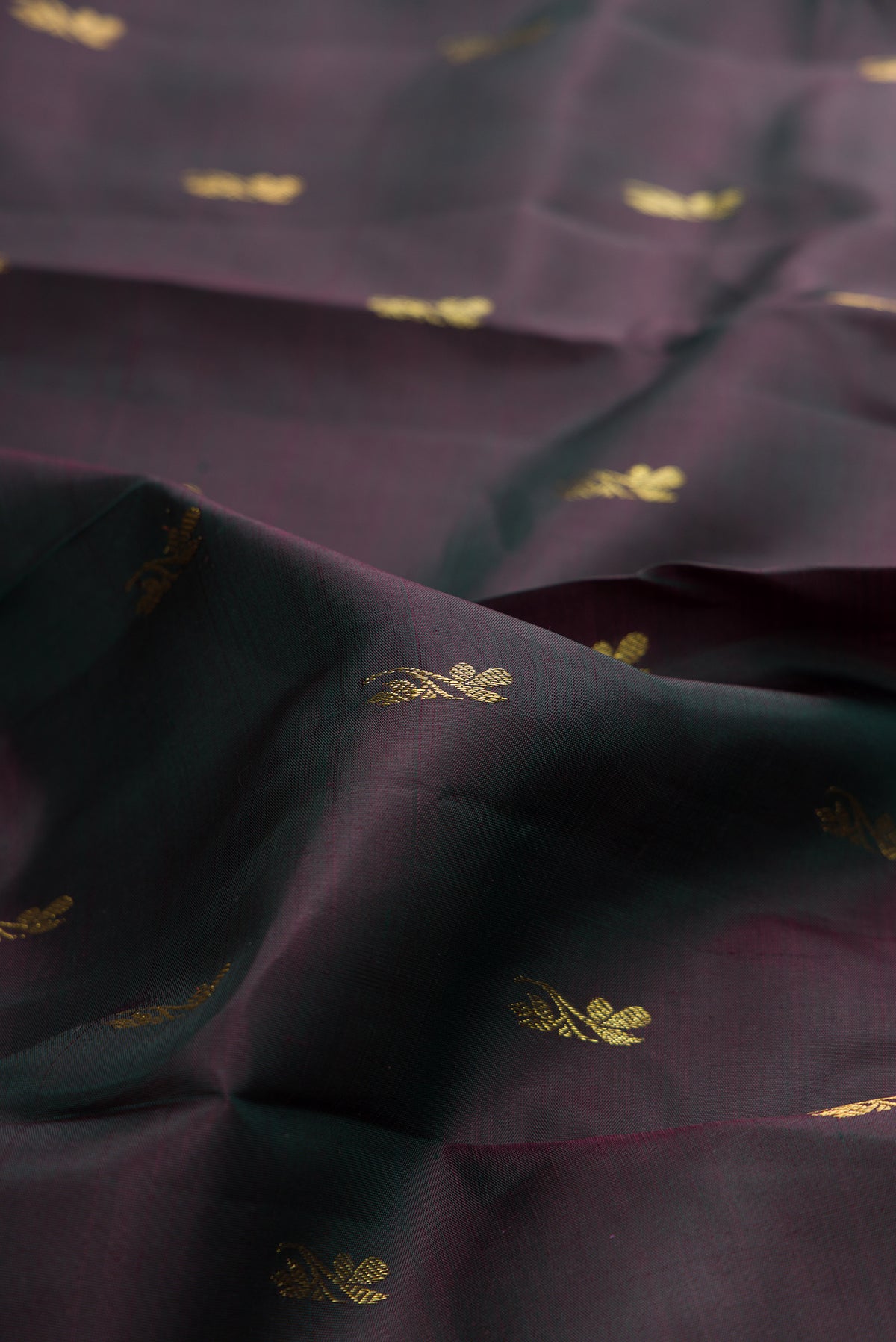 Close up of Pure Silk Bottle Green with Maroon Color Kanjivaram Saree with Zari Butta on the body and Zari Border.  displaying folds