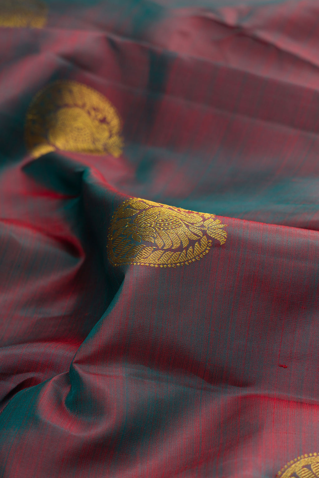 Close up of Pure Silk Green with Red Color Kanchipuram Saree with Zari Butta on the body and Zari Border.  displaying folds