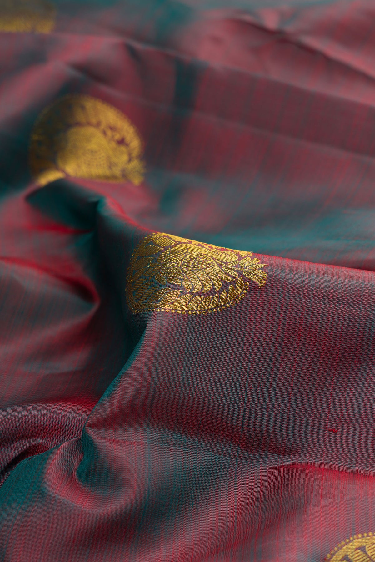 Close up of Pure Silk Green with Red Color Kanchipuram Saree with Zari Butta on the body and Zari Border.  displaying folds