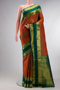 Pure Silk Rust Kanchipuram Saree with Zari Butta on the body and Zari Border.  displayed on a mannequin