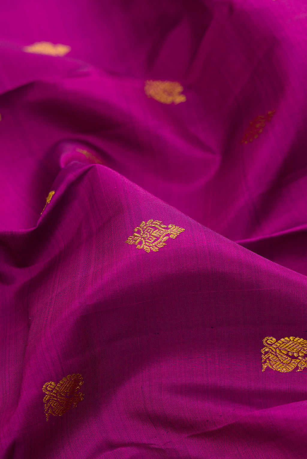 Close up of Pure Silk Magenta Kanjivaram Saree with Zari Butta on the body and Zari Border.  displaying folds