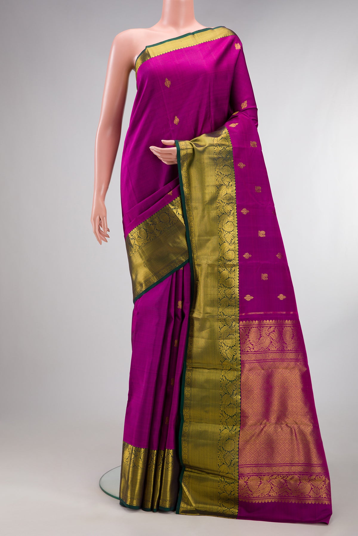 Pure Silk Magenta Kanjivaram Saree with Zari Butta on the body and Zari Border.  displayed on a mannequin