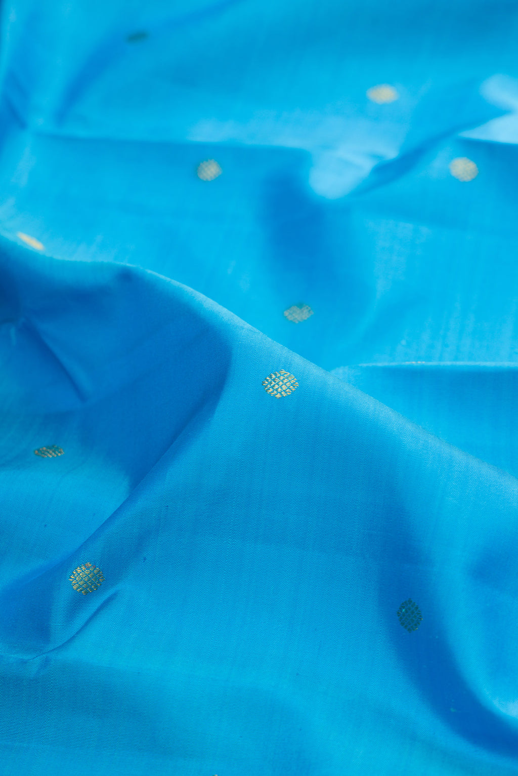 Close up of Pure Silk Sky Blue Kanjivaram Saree with Zari Butta on the body and Zari Border.  displaying folds