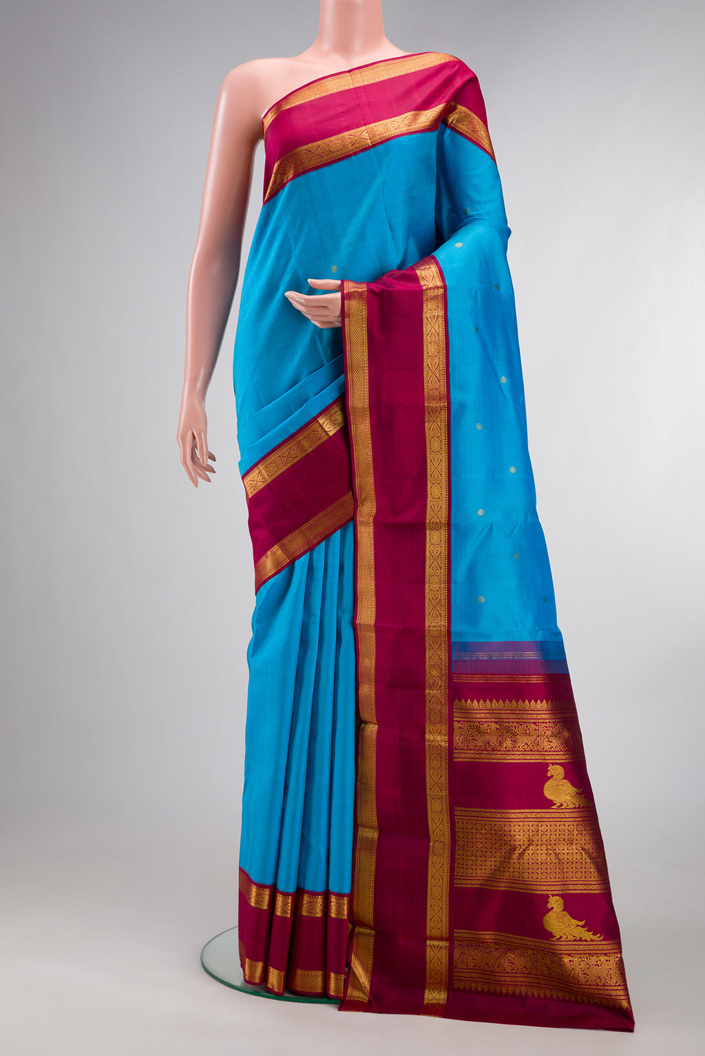 Pure Silk Sky Blue Kanjivaram Saree with Zari Butta on the body and Zari Border.  displayed on a mannequin