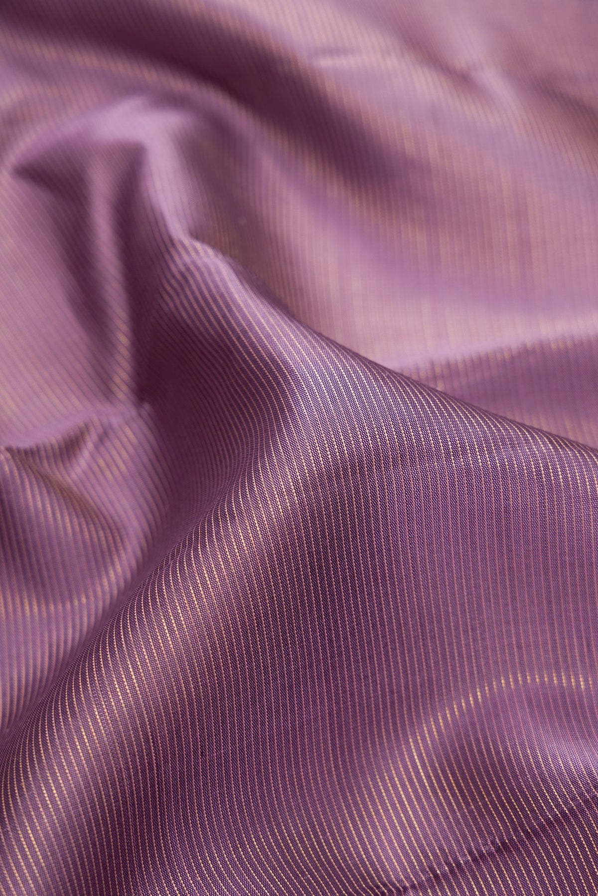 Close up of Pure Silk Mauve Kanjivaram Saree with Stripes on the body and Zari Border.  displaying folds