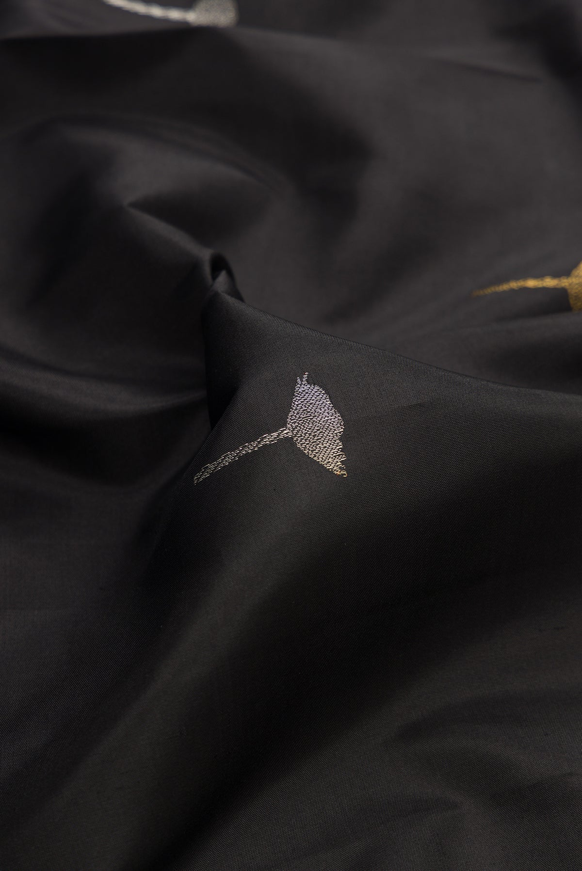 Close up of Pure Silk Black Kanchipuram Saree with Zari Butta on the body and Without Border.  displaying folds