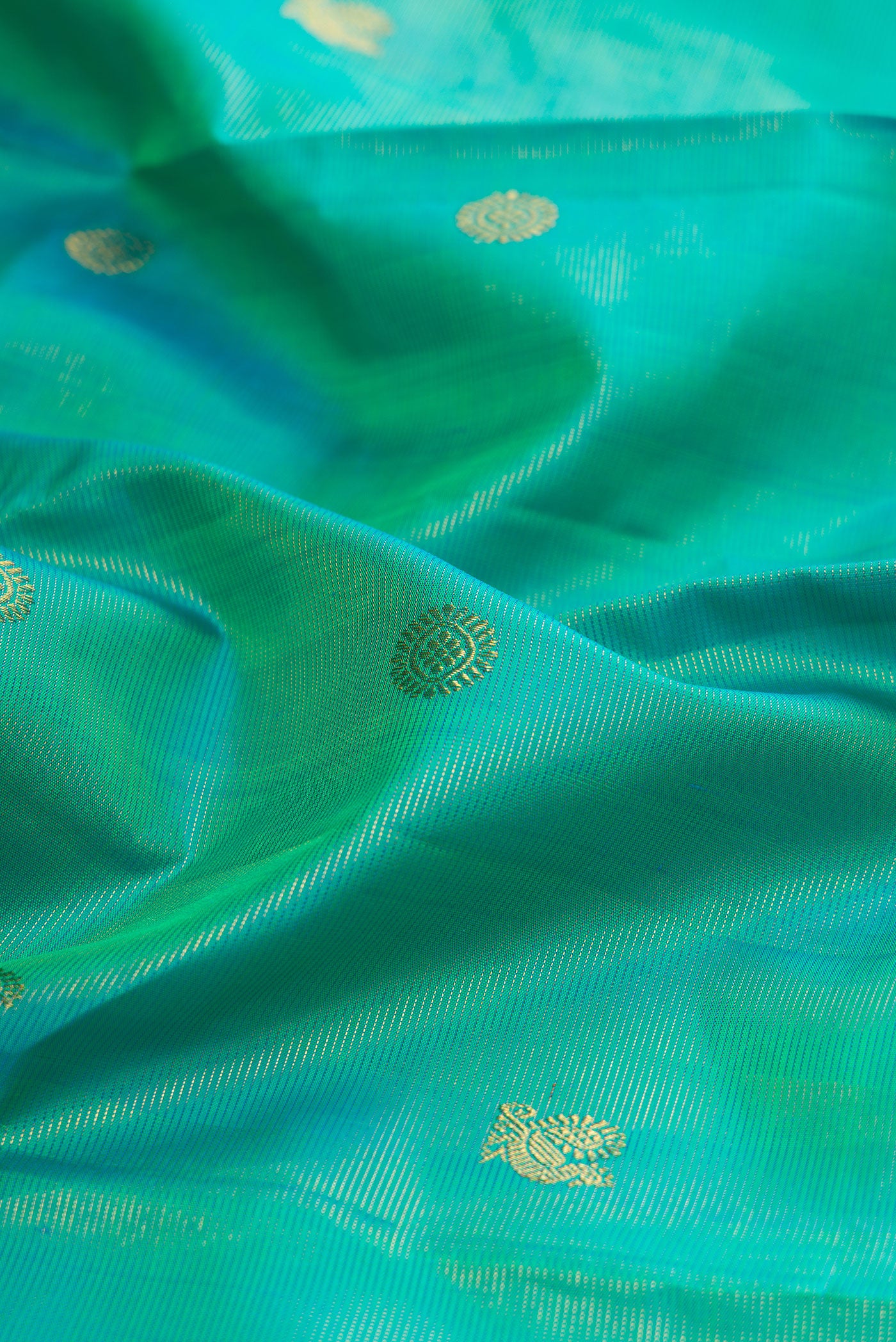 Close up of Pure Silk Turquoise Kanjivaram Saree with Zari Butta on the body and Zari Border.  displaying folds