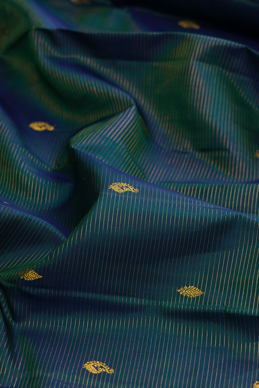 Close up of Pure Silk Peacock Blue Kanjivaram Saree with Stripes on the body and Zari Border.  displaying folds