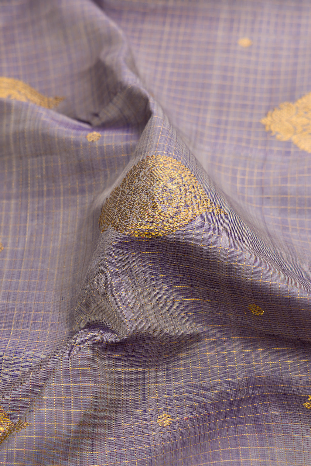 Close up of Pure Silk Lilac Dual Tone Kanjivaram Saree with Zari Butta on the body and Zari Border.  displaying folds