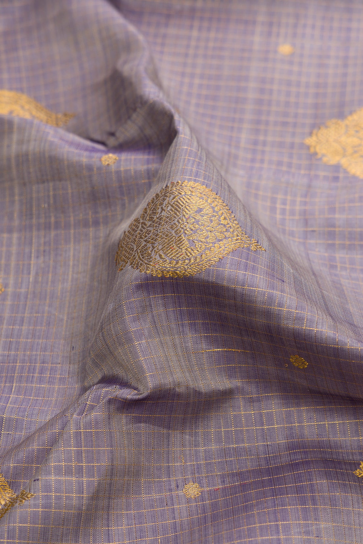 Close up of Pure Silk Lilac Dual Tone Kanjivaram Saree with Zari Butta on the body and Zari Border.  displaying folds