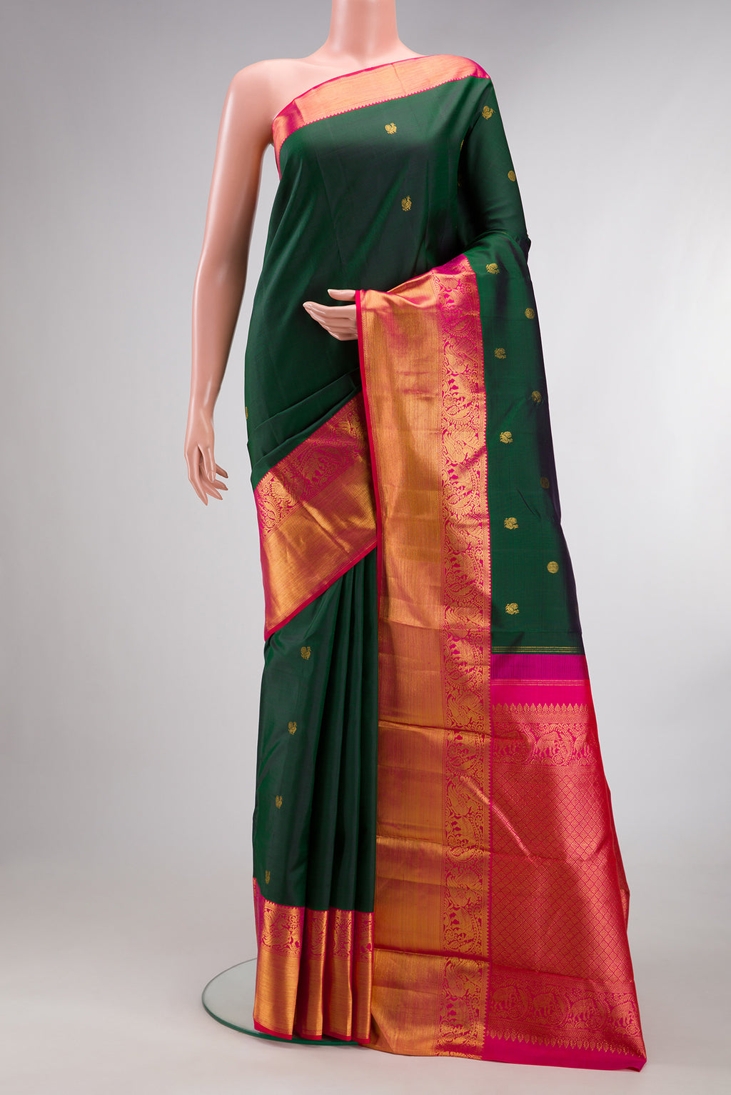 Pure Silk Bottle Green Kanjivaram Saree with Zari Butta on the body and Zari Border.  displayed on a mannequin