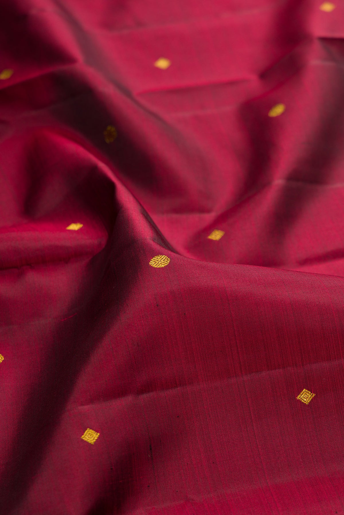 Close up of Pure Silk Maroon Kanjivaram Saree with Zari Butta on the body and Zari Border.  displaying folds