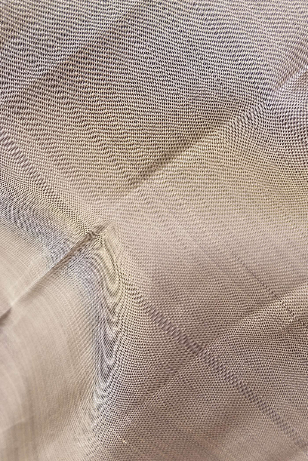 Close up of Pure Silk Grey Kanchipuram Saree with Plain Body and Zari Border.  displaying folds