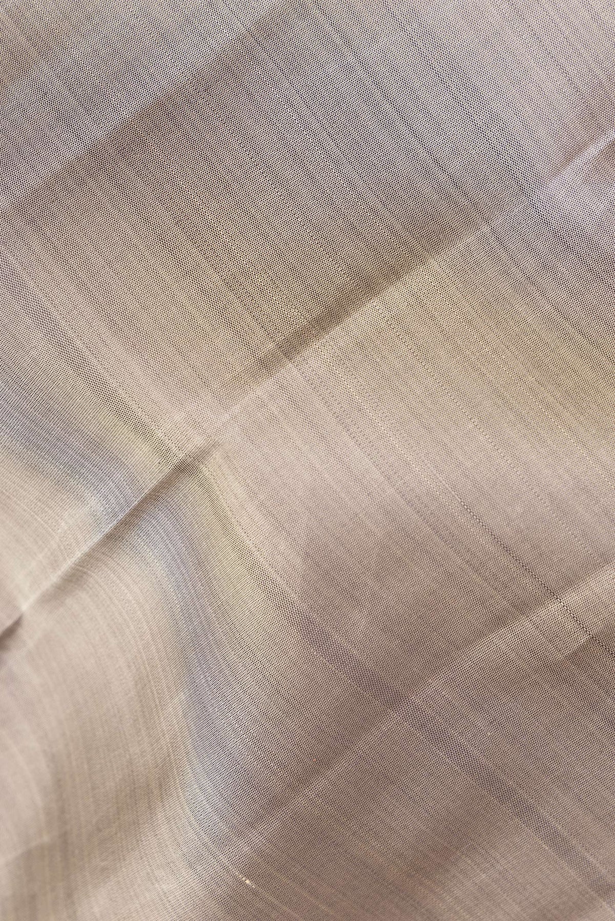 Close up of Pure Silk Grey Kanchipuram Saree with Plain Body and Zari Border.  displaying folds
