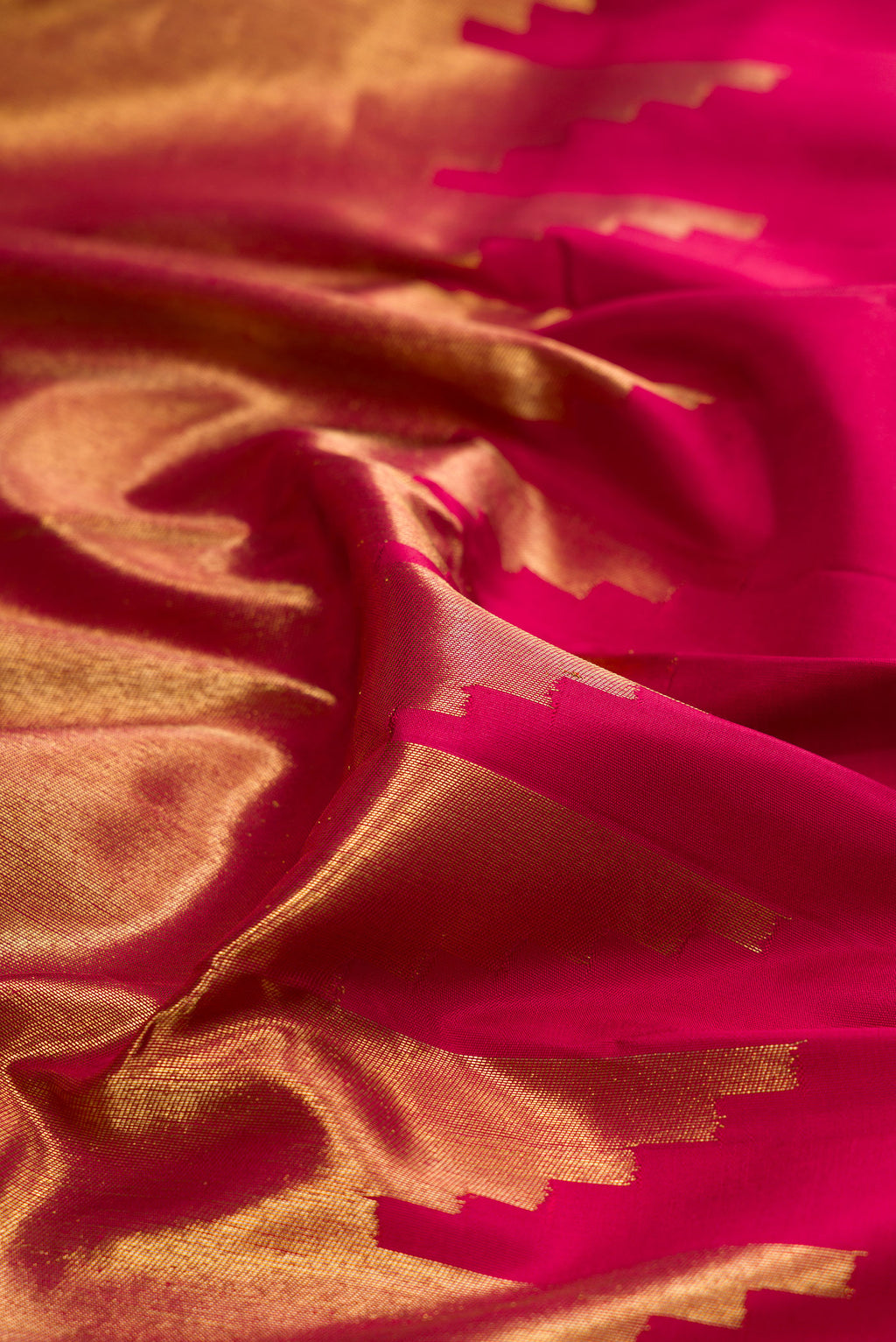 Close up of Pure Silk Pure Zari Maroon Kanjivaram Saree with Plain Body and Rising Temple Border.  displaying folds