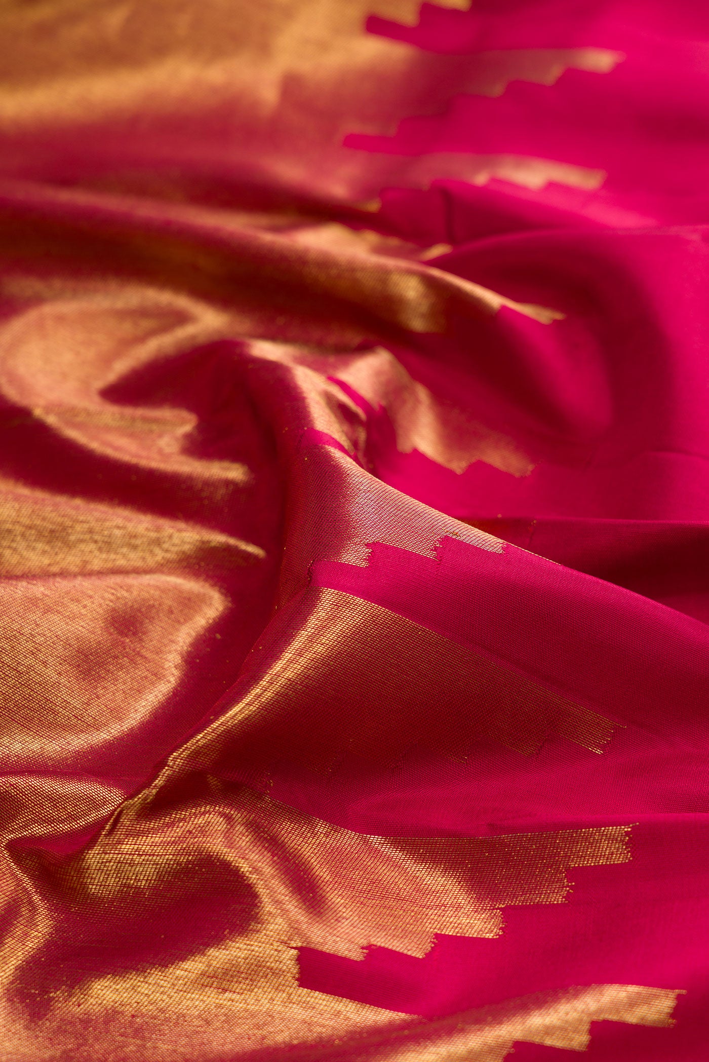 Close up of Pure Silk Pure Zari Maroon Kanjivaram Saree with Plain Body and Rising Temple Border.  displaying folds