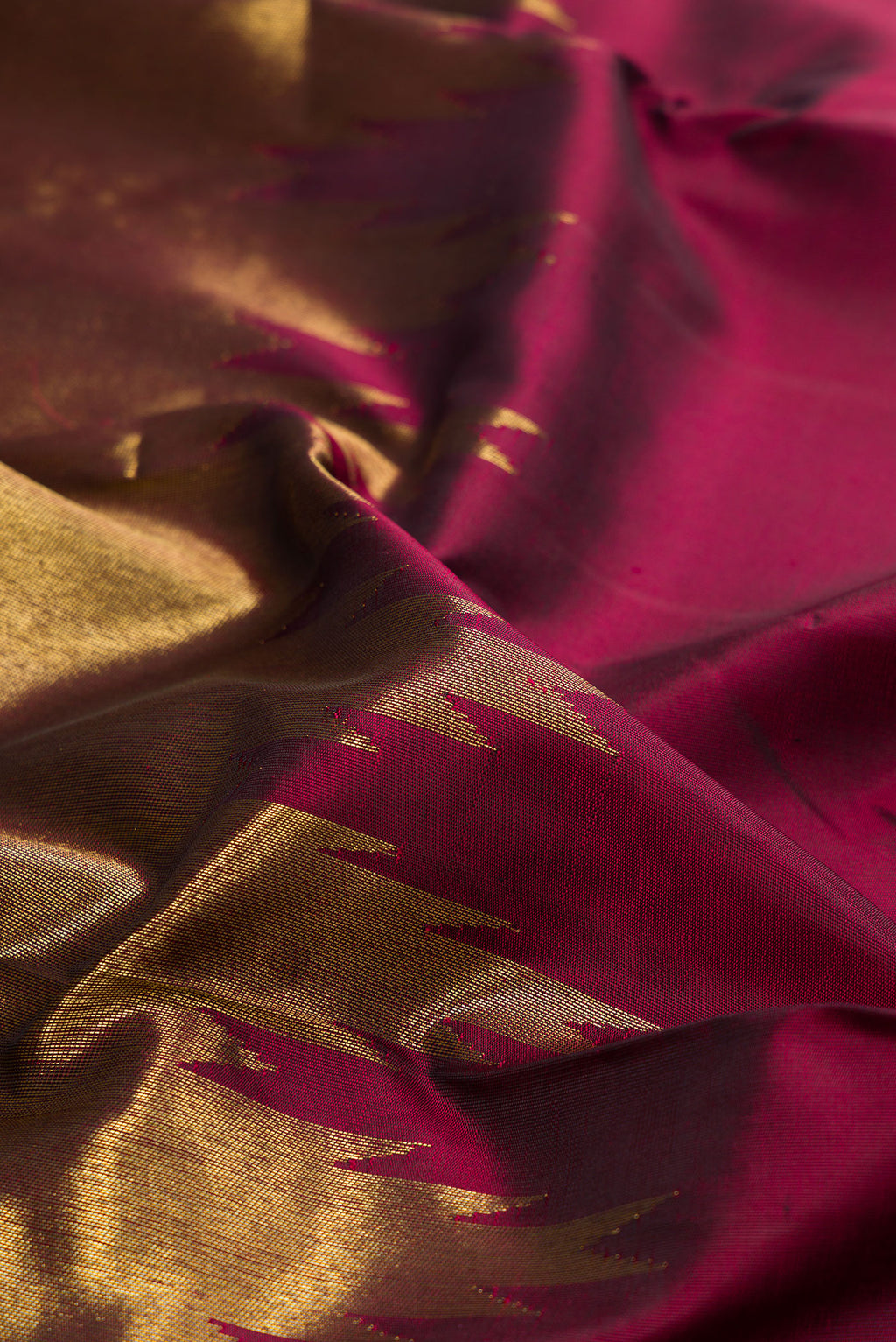 Close up of Pure Silk Pure Zari Maroon Kanjivaram Saree with Plain Body and Rising Temple Border.  displaying folds