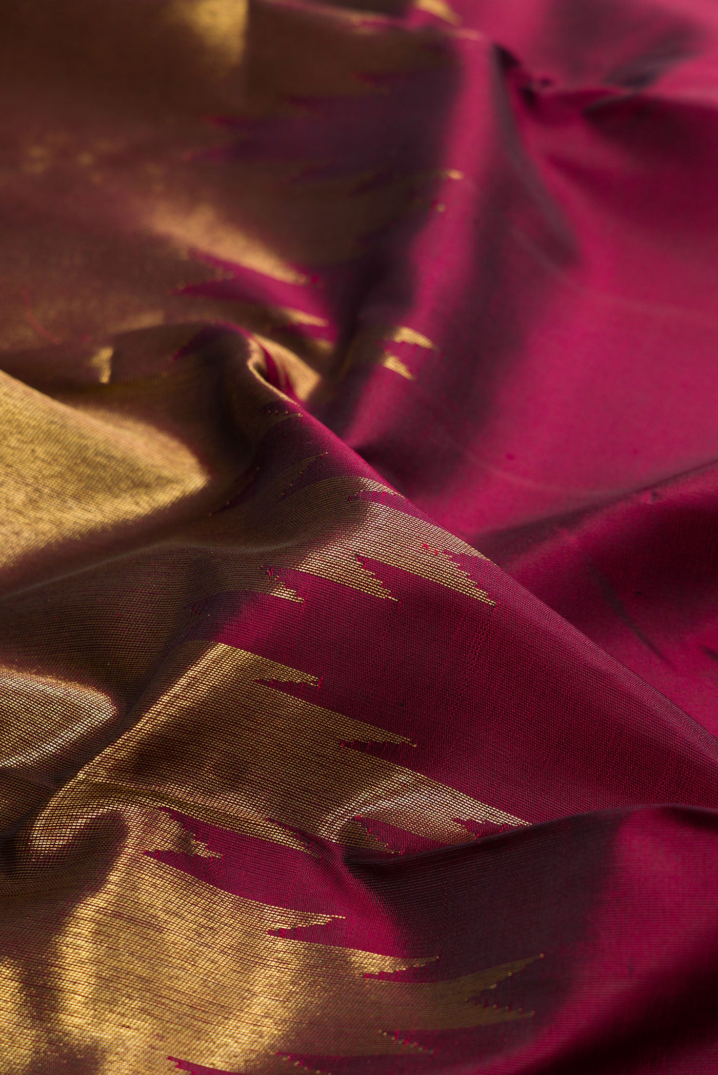 Close up of Pure Silk Pure Zari Maroon Kanjivaram Saree with Plain Body and Rising Temple Border.  displaying folds