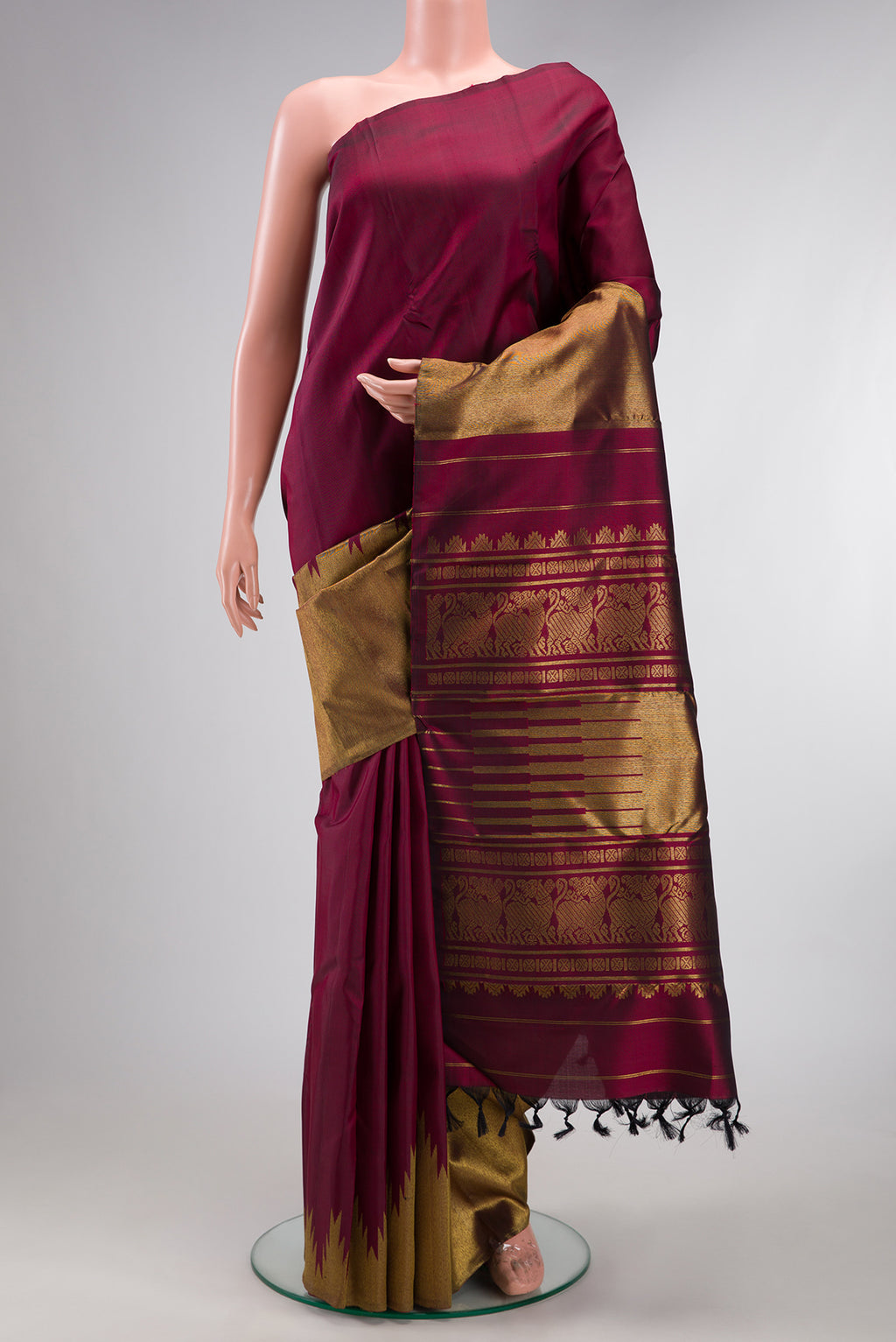 Pure Silk Pure Zari Maroon Kanjivaram Saree with Plain Body and Rising Temple Border.  displayed on a mannequin