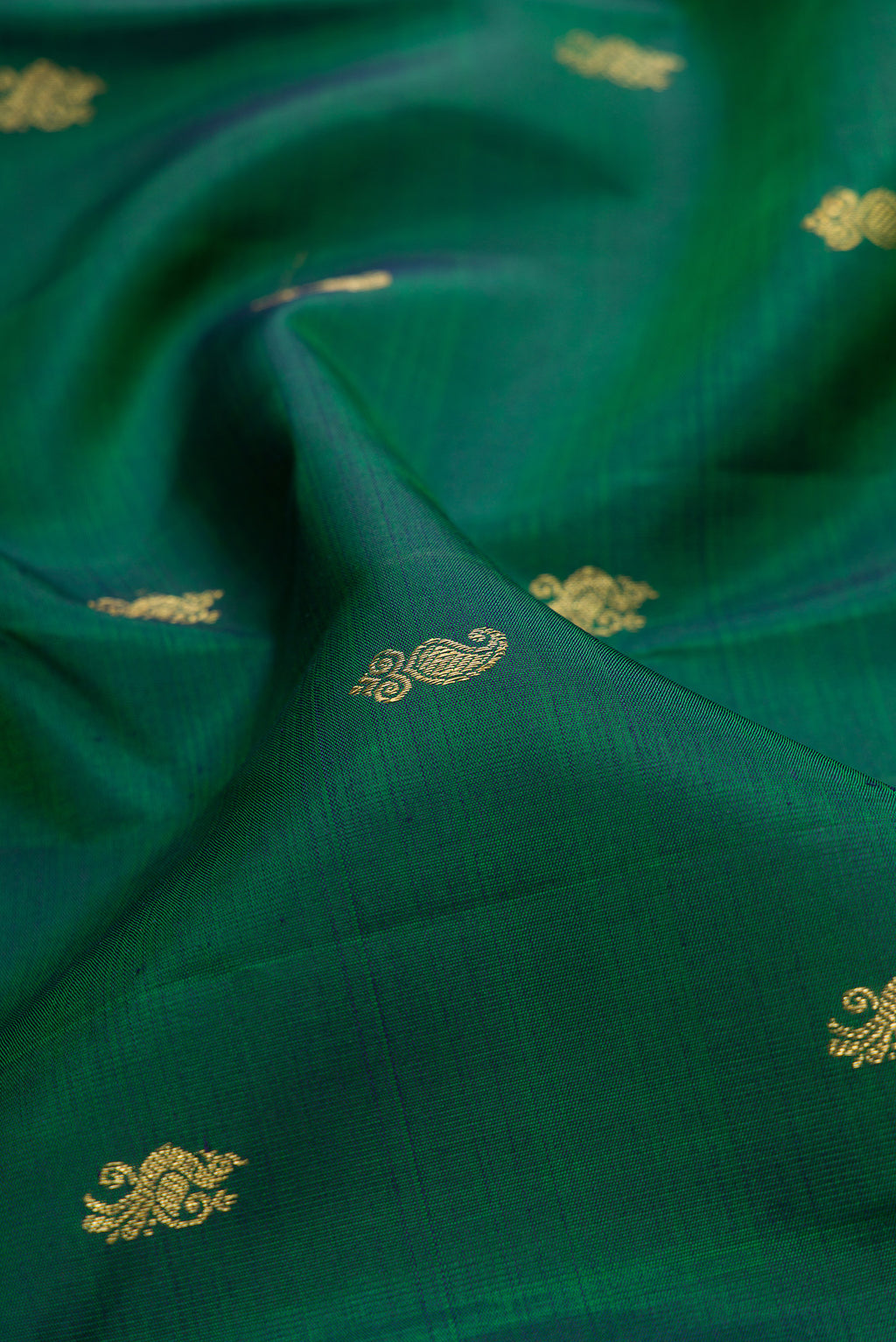 Close up of Pure Silk Pure Zari Green Dual Tone Kanjivaram Saree with Zari Butta on the body and Zari Border.  displaying folds