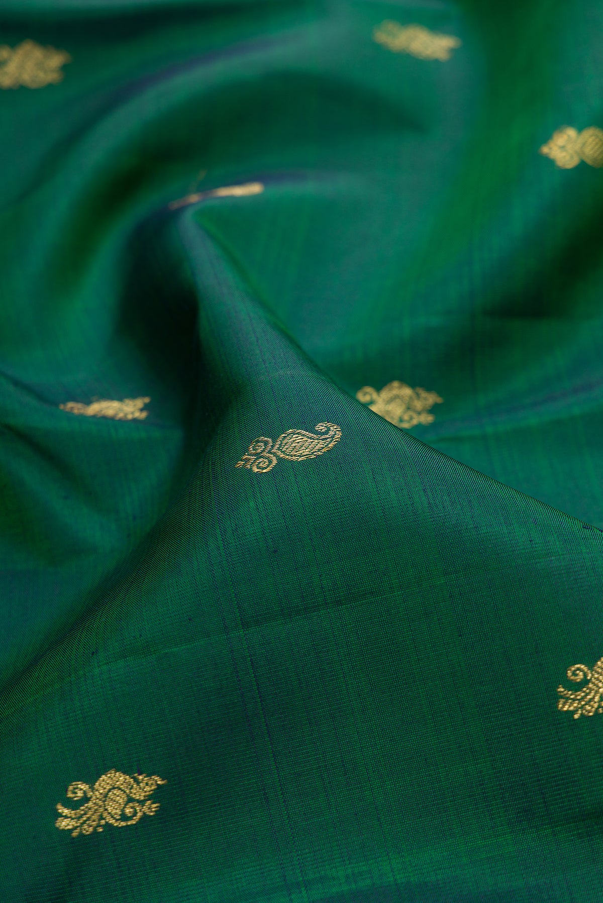 Close up of Pure Silk Pure Zari Green Dual Tone Kanjivaram Saree with Zari Butta on the body and Zari Border.  displaying folds