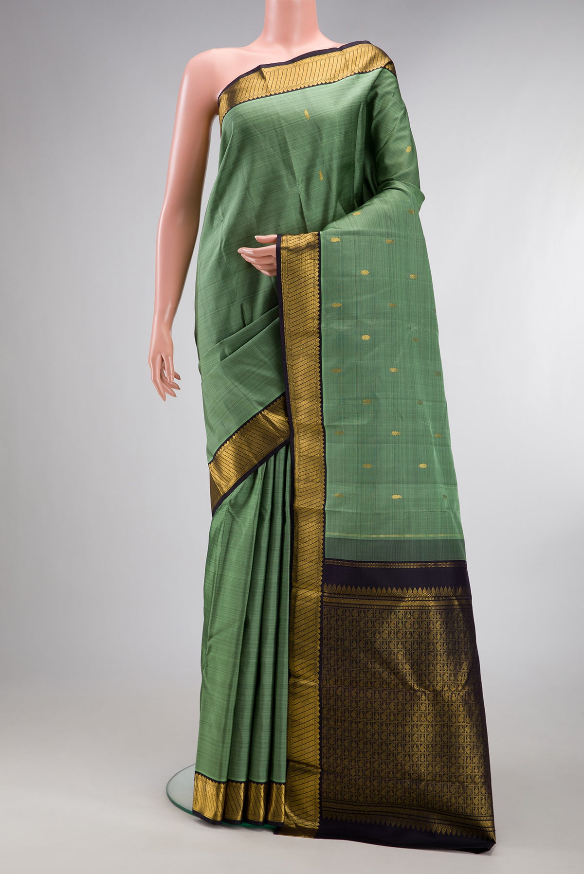 Pure Silk Sage Green Kanchipuram Saree with Zari Butta on the body and Zari Border.  displayed on a mannequin