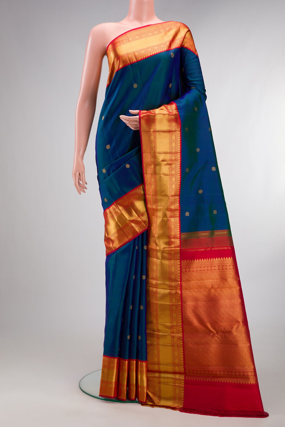 Pure Silk Peacock Blue Dual Tone Kanchipuram Saree with Zari Butta on the body and Zari Border.  displayed on a mannequin