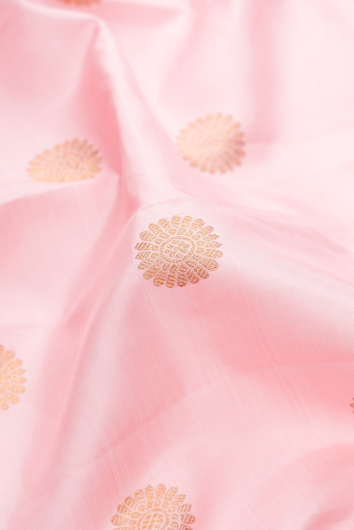 Close up of Pure Silk Rose pink Kanchipuram Saree with Zari Butta on the body and Zari Border.  displaying folds