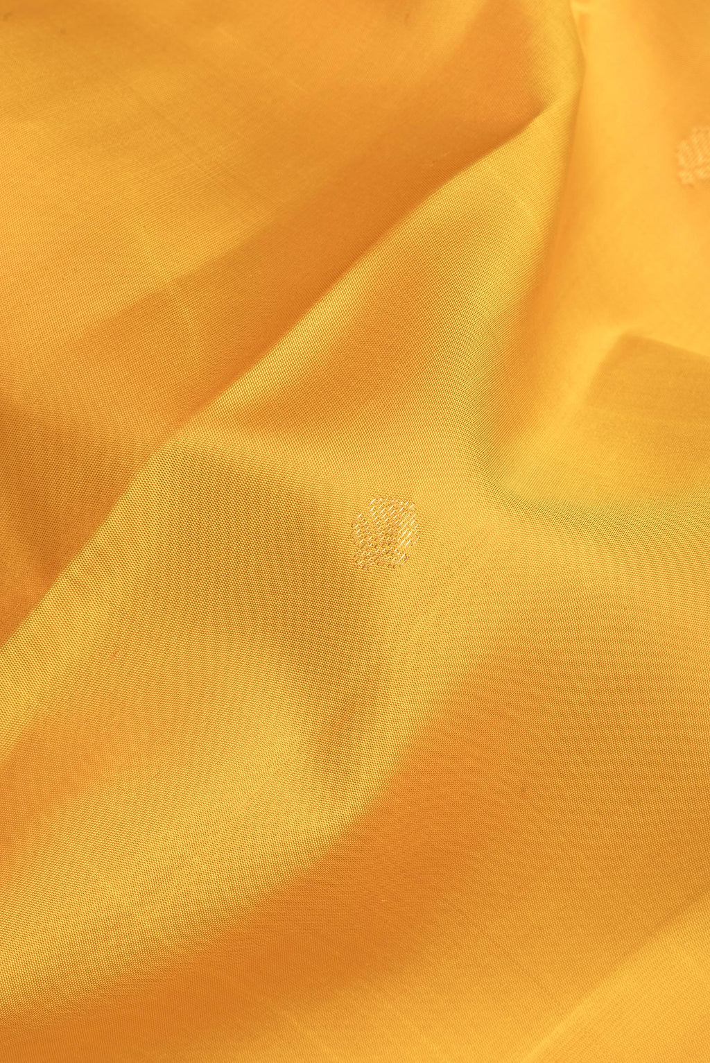 Close up of Pure Silk Yellow Dual Tone Kanjivaram Saree with Zari Butta on the body and Fancy Border.  displaying folds