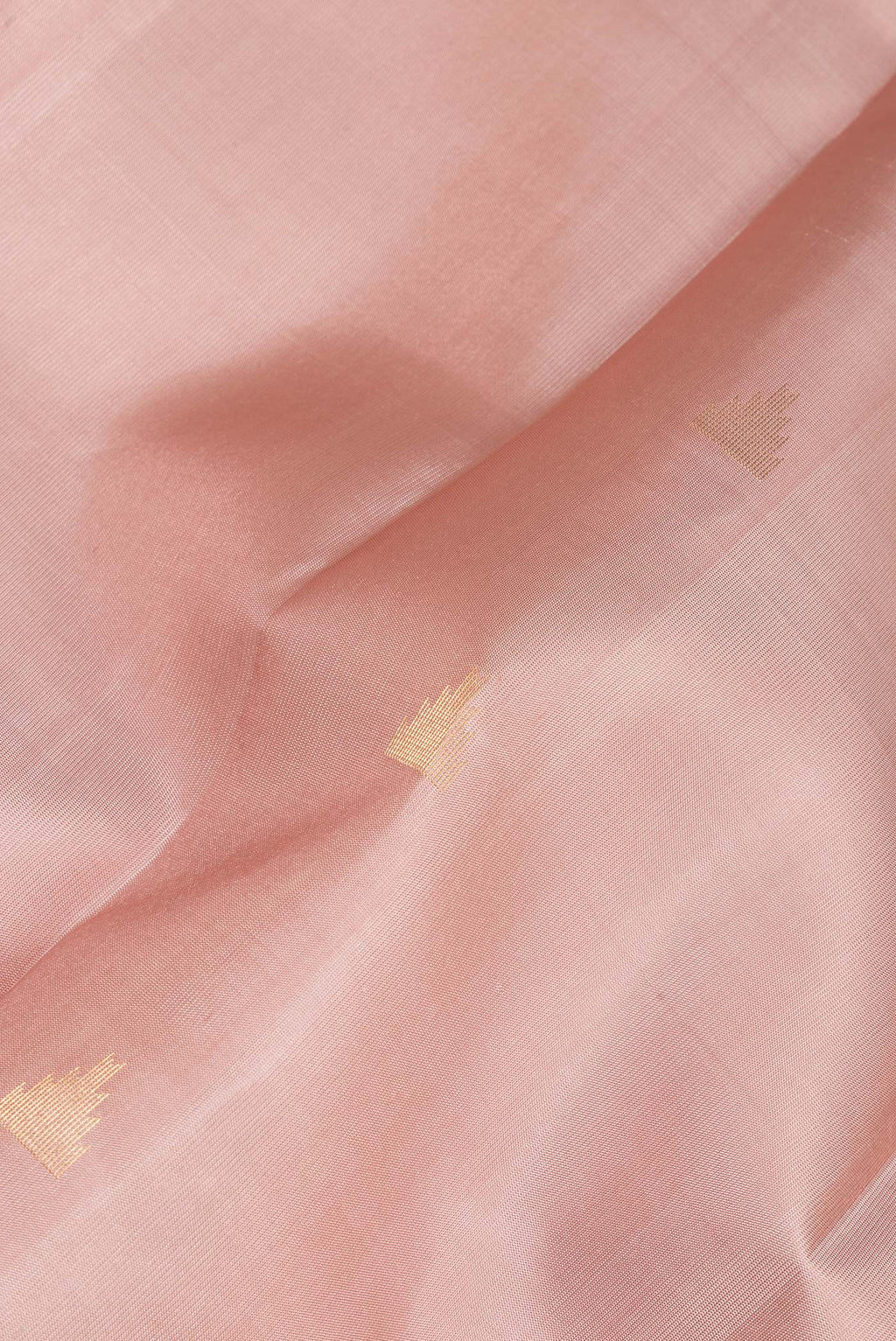 Close up of Pure Silk Rose Gold Kanchipuram Saree with Zari Butta on the body and Zari Border.  displaying folds