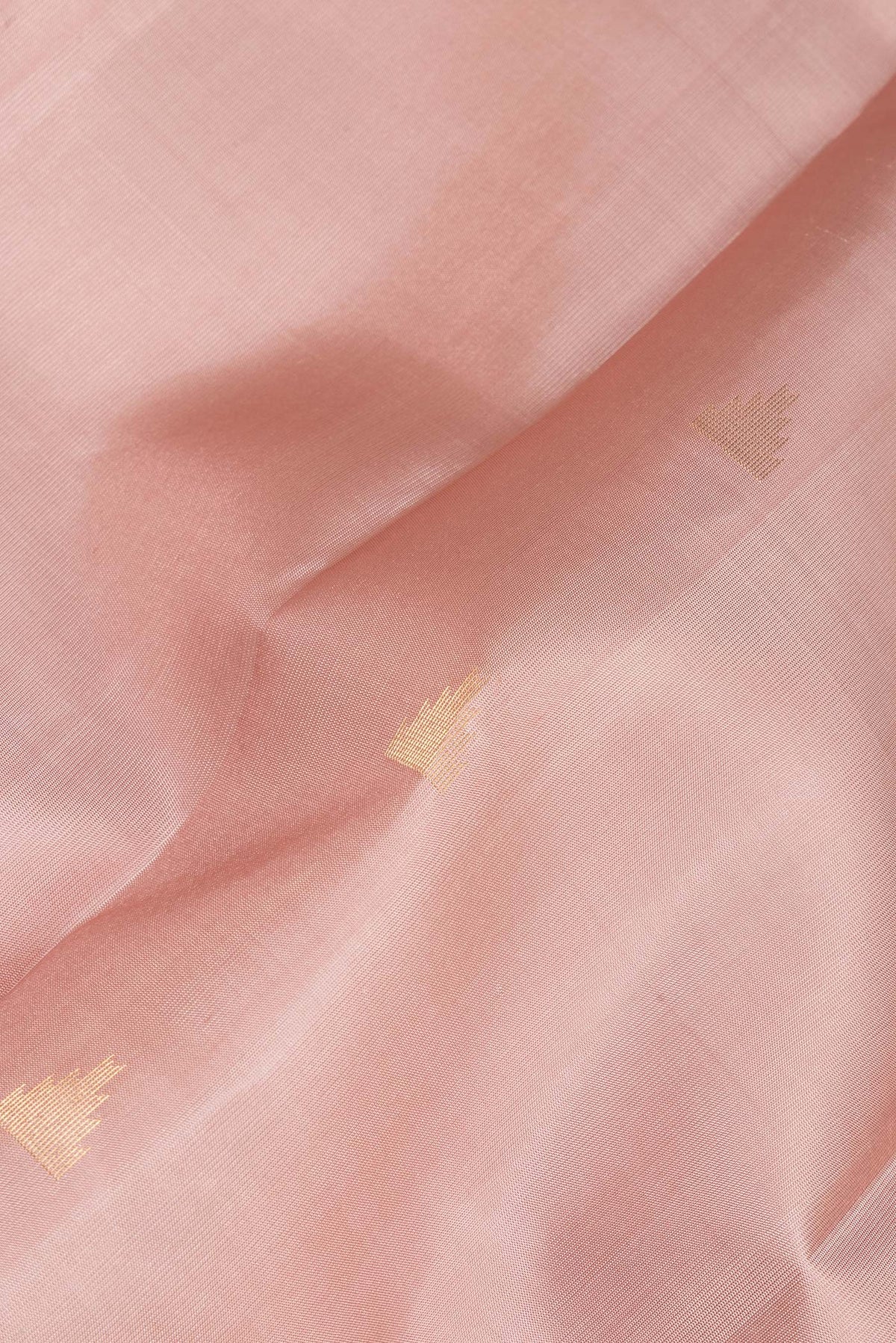Close up of Pure Silk Rose Gold Kanchipuram Saree with Zari Butta on the body and Zari Border.  displaying folds